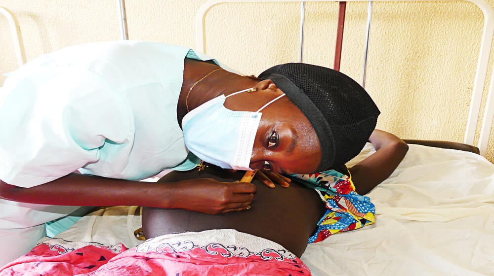 La sage-femme Maria Cá procède à l'auscultation du bébé d'Edna lors de sa consultation de grossesse. @UNFPA Guinée-Bissau