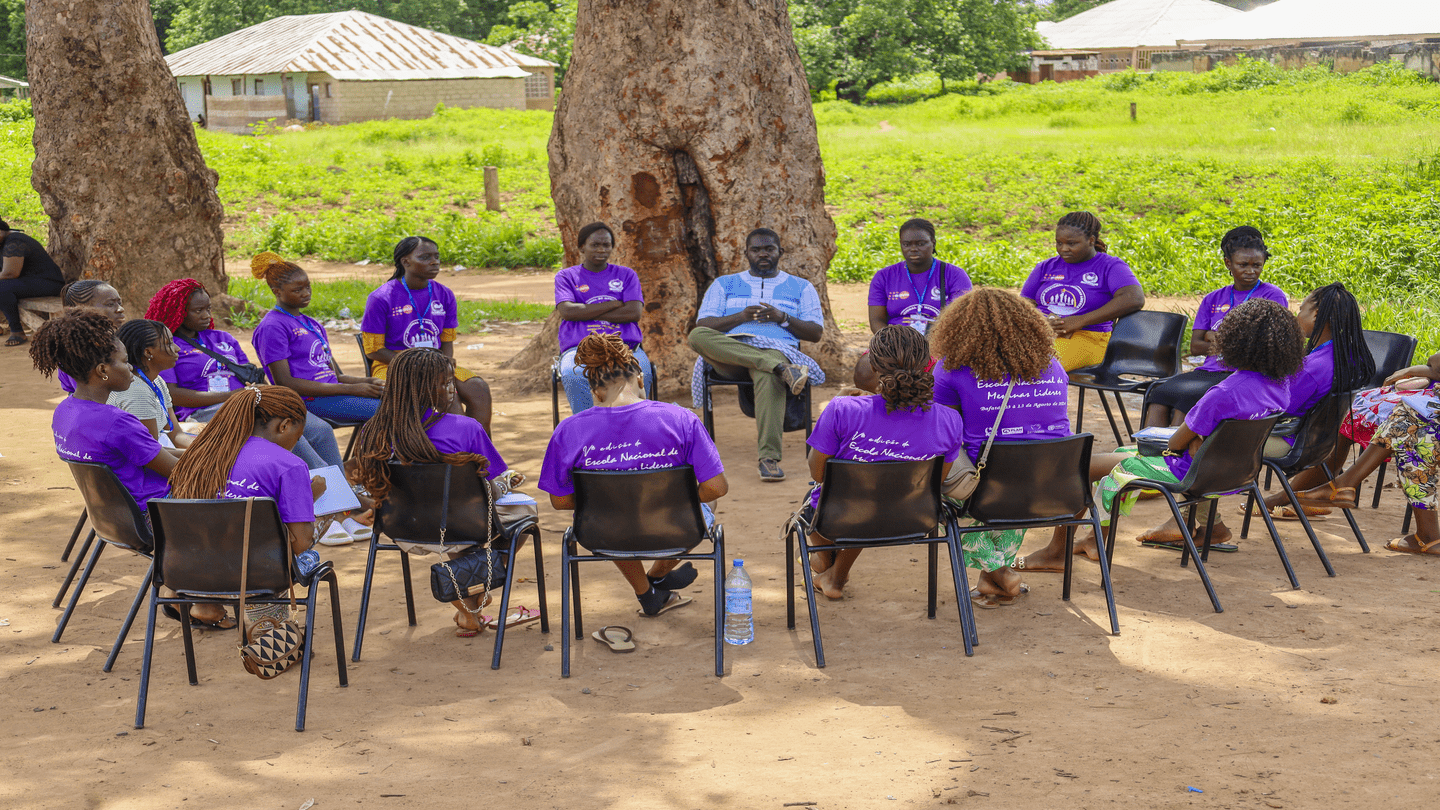 Youths gathering around during a summer camp learning session.